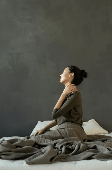 woman-in-gray-dress-sitting-on-bed