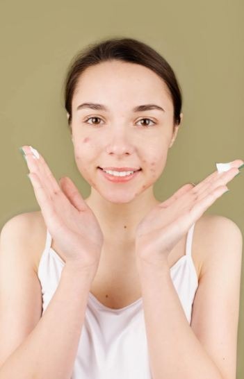 woman-in-white-tank-top-with-facial-cream-on-her-hands