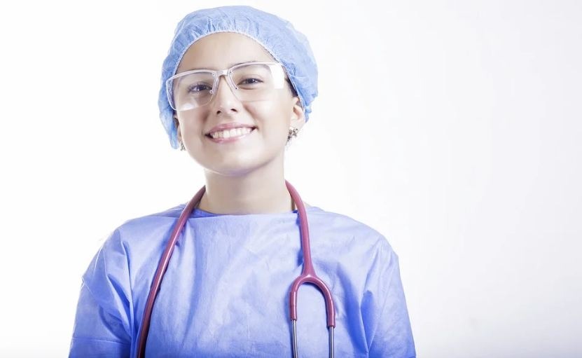 A woman in doctor uniform standing ignorant of a white wall for the background