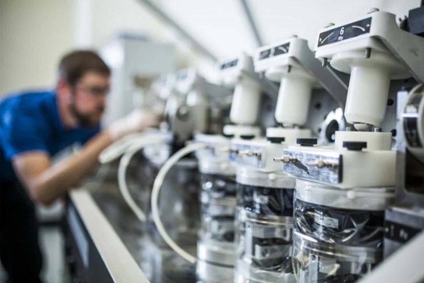 Laboratory microscopes with a doctor blurred in the background