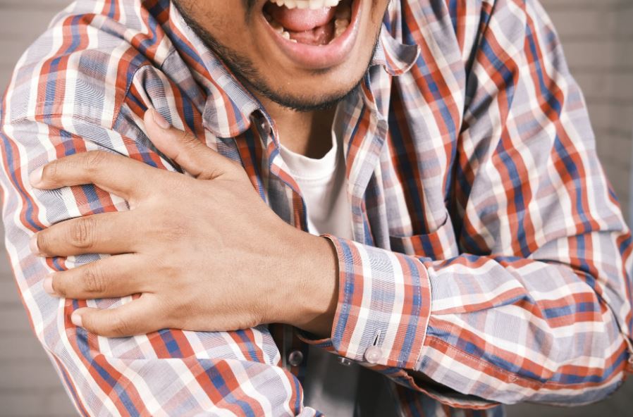 a man in pain holding his arm