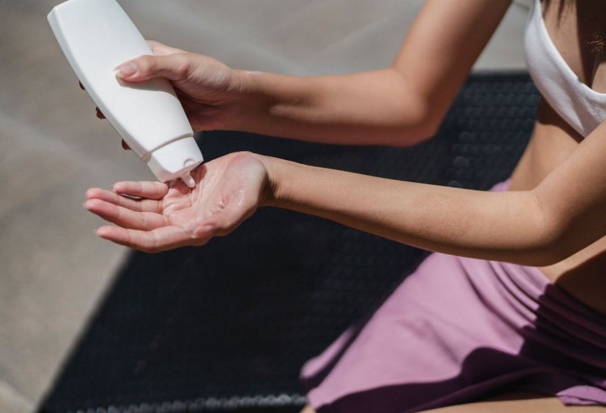 a woman pouring sunscreen on her hand