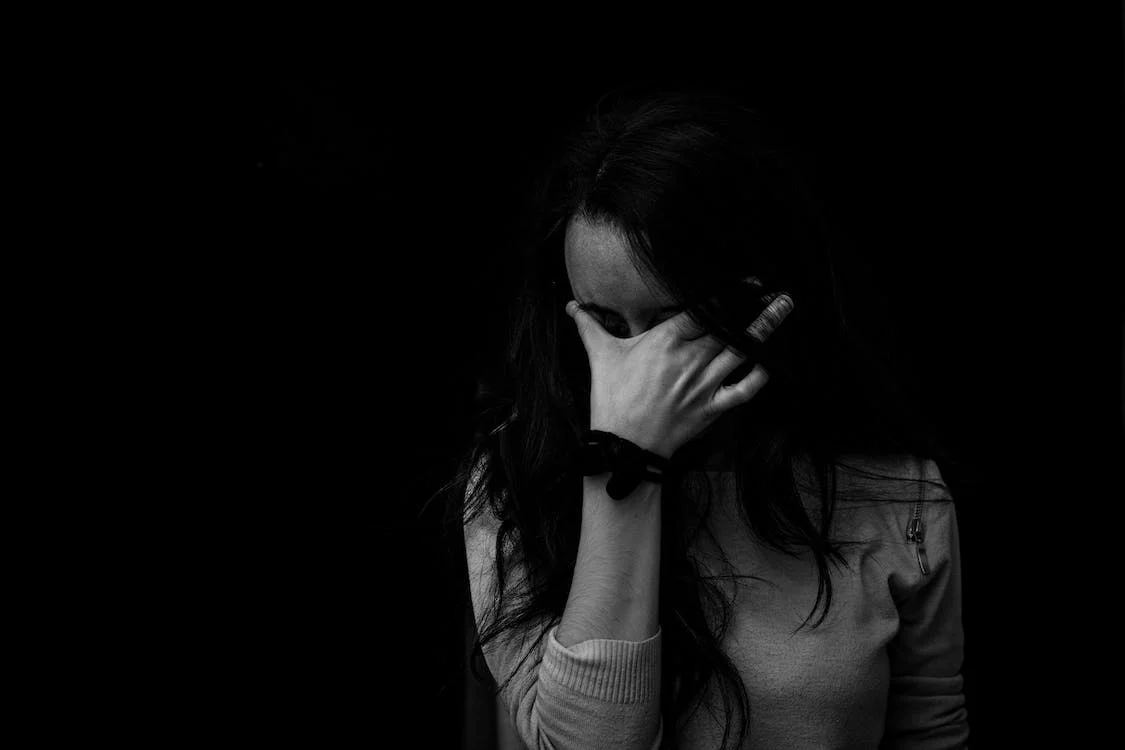 grayscale photography of a woman touching her eyes