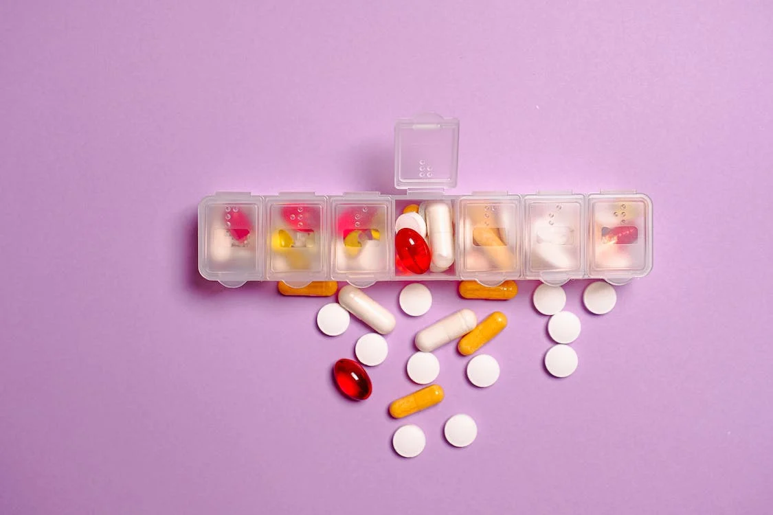Clear plastic medicine container on the violet surface
