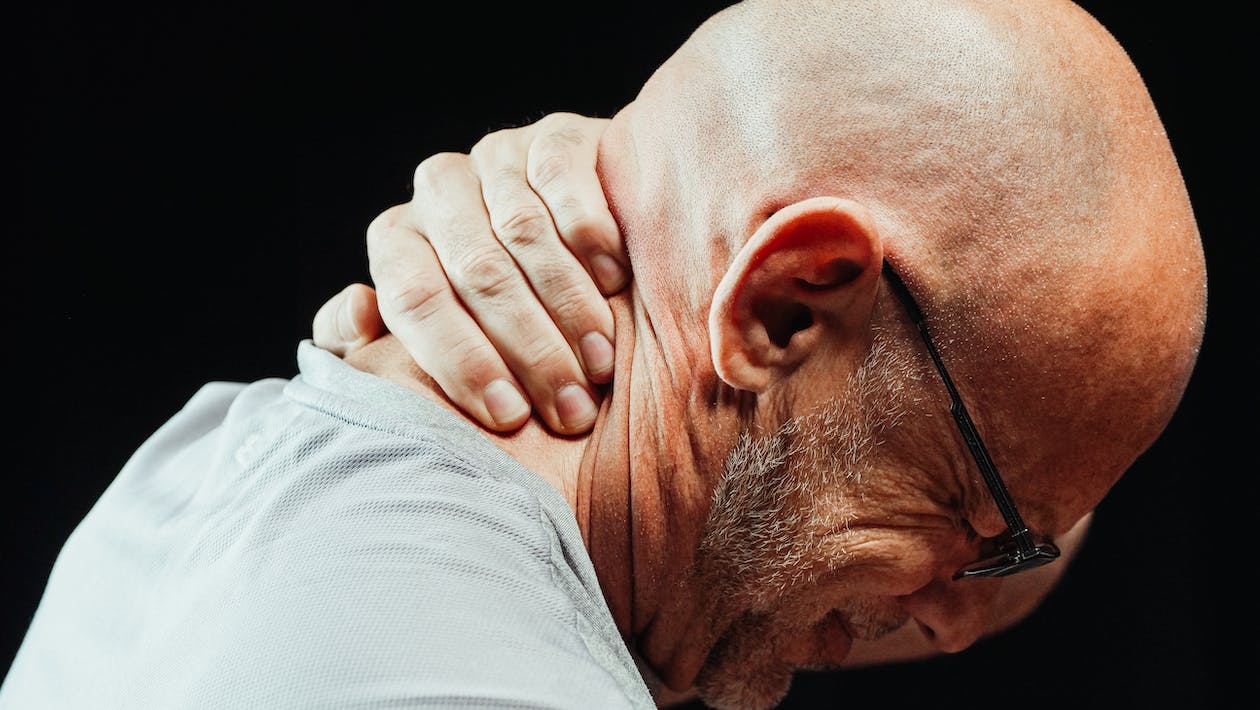 close-up photo of a man having a neck pain
