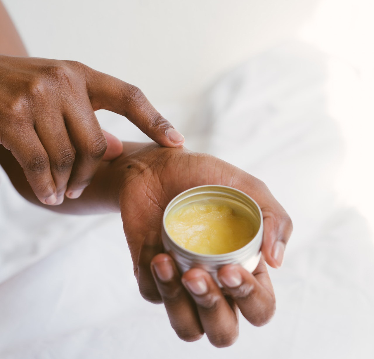 The person holding a hand cream