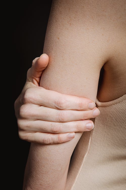 crop person with hand holding arm