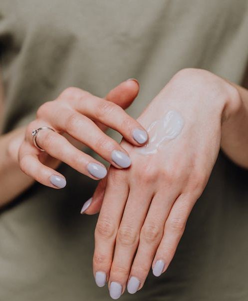 crop-woman-applying-cream-on-hands