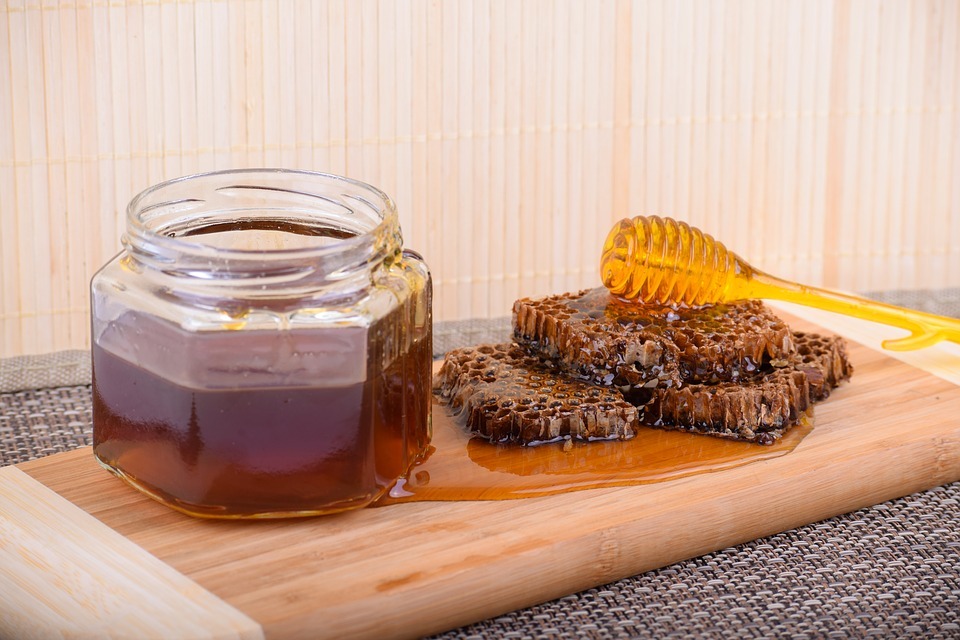 A jar of raw honey with honeycomb