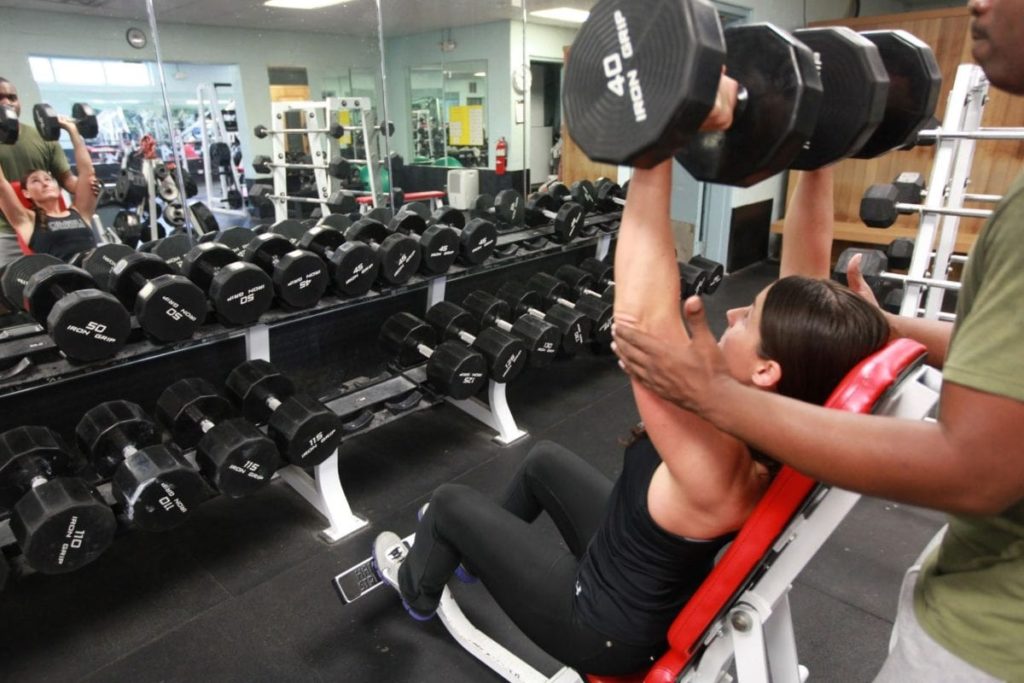 Young woman lifting heavy weights at the gym