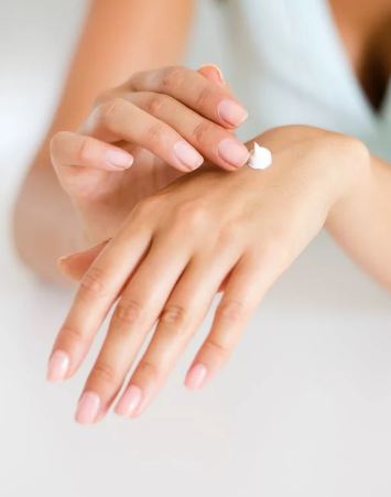 woman applying cream on hand