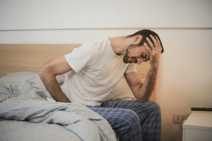 young-man-in-sleepwear-suffering-from-headache-in-morning