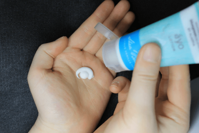 A woman putting lotion on her palm