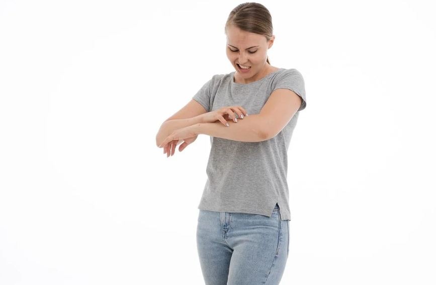 a woman itching her arm