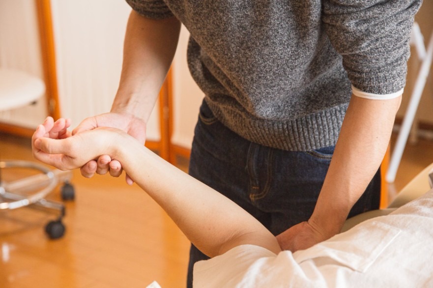 a chiropractor holding the arm of a patient