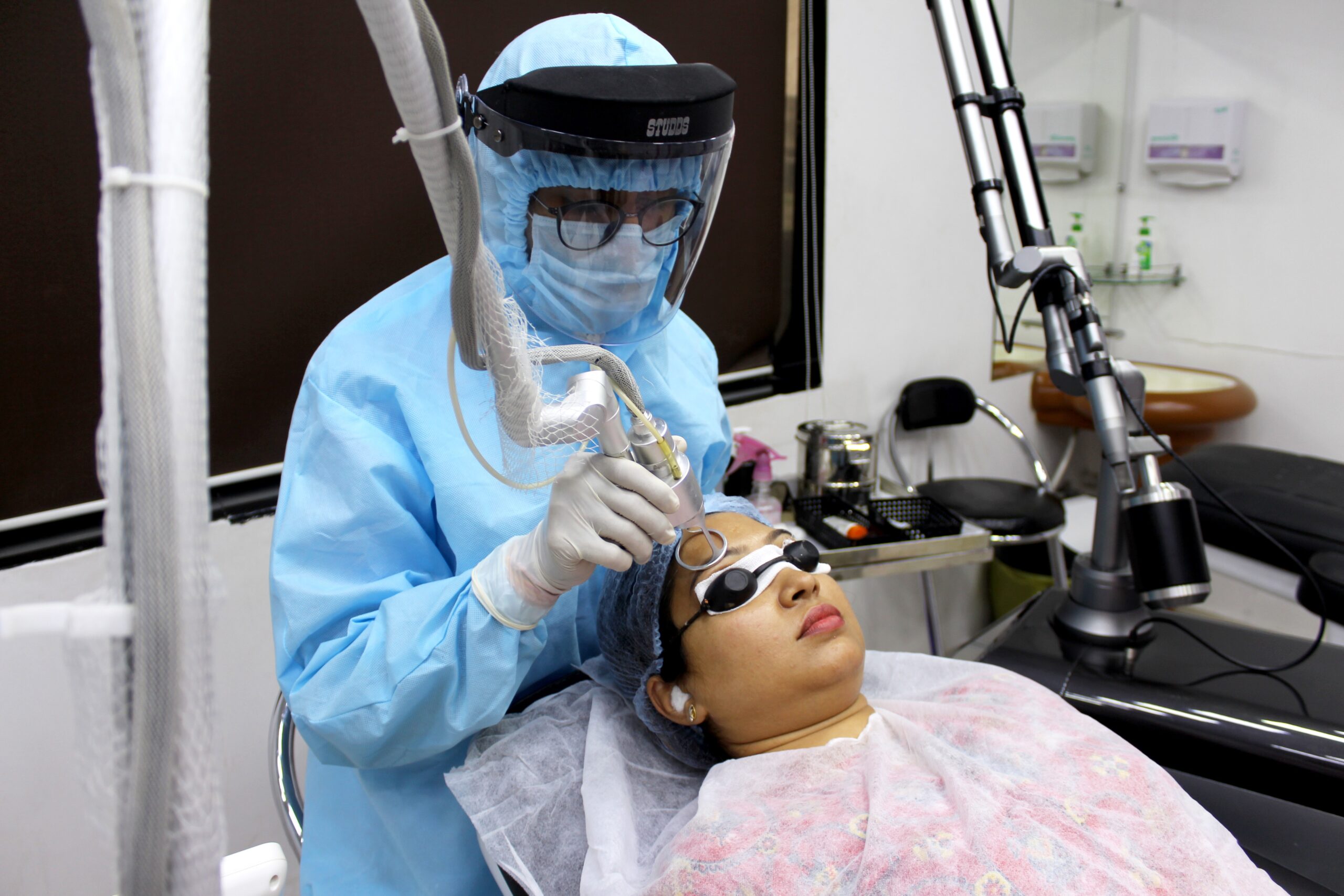 a doctor doing a facial treatment on a patient