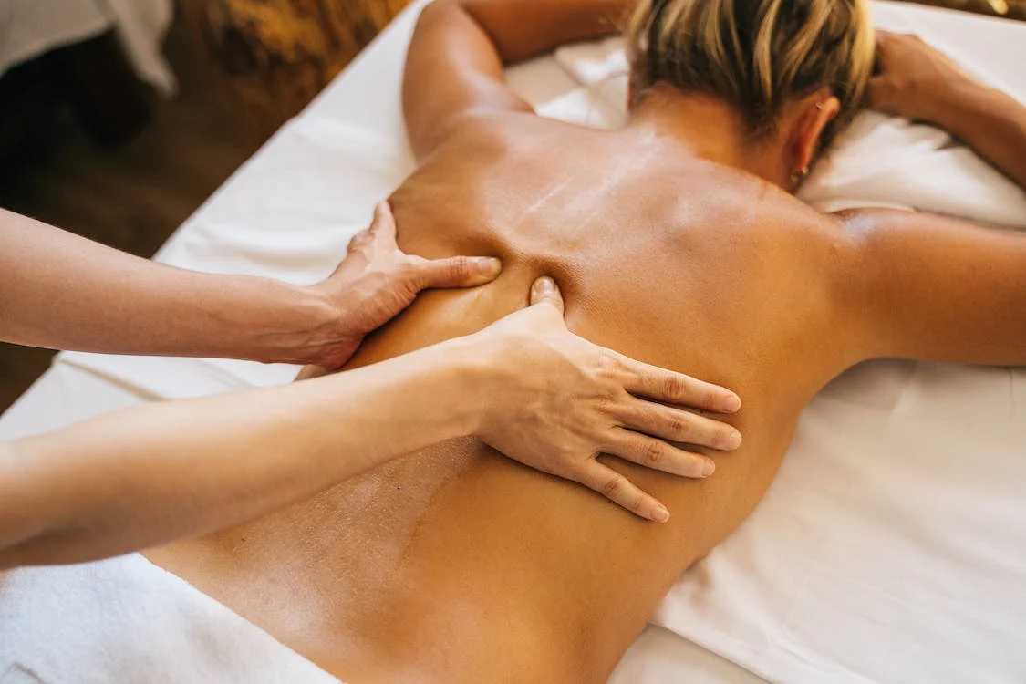 a person massaging a client’s bareback