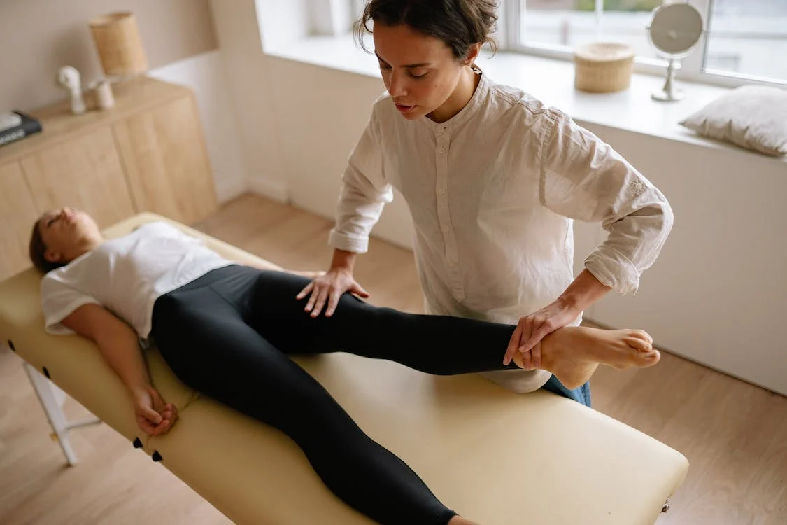 physiotherapist holding woman's legs