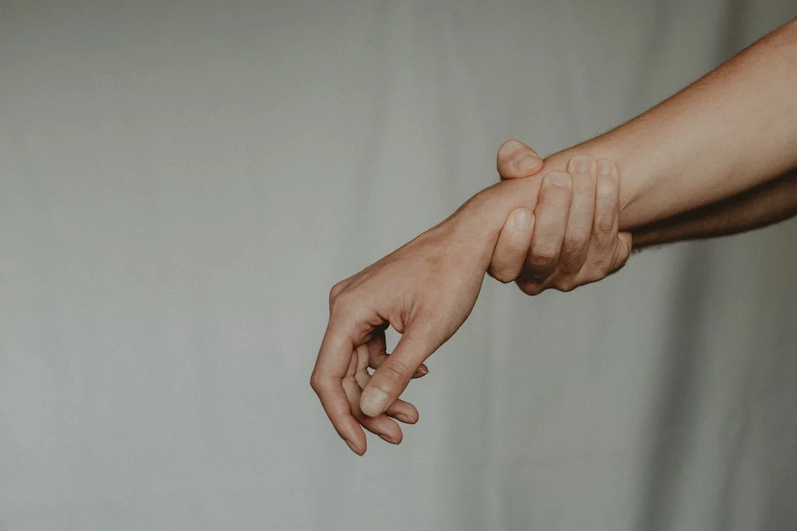 unrecognizable person holding the hand of partner abusively